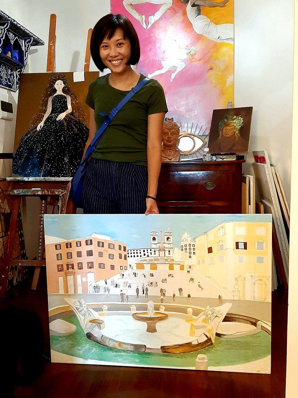 Allieva adulta al lavoro tra le tele durante un corso di pittura a Roma